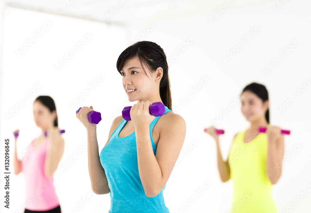 young woman doing exercise with dumbbell in gym young woman doing exercise with dumbbell in gym