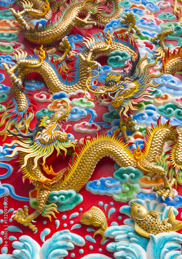 The golden dragon statue on wall at chinese temple