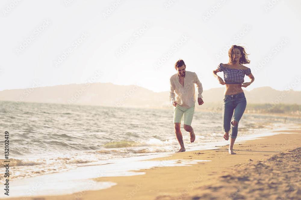 happy couple running on the beach