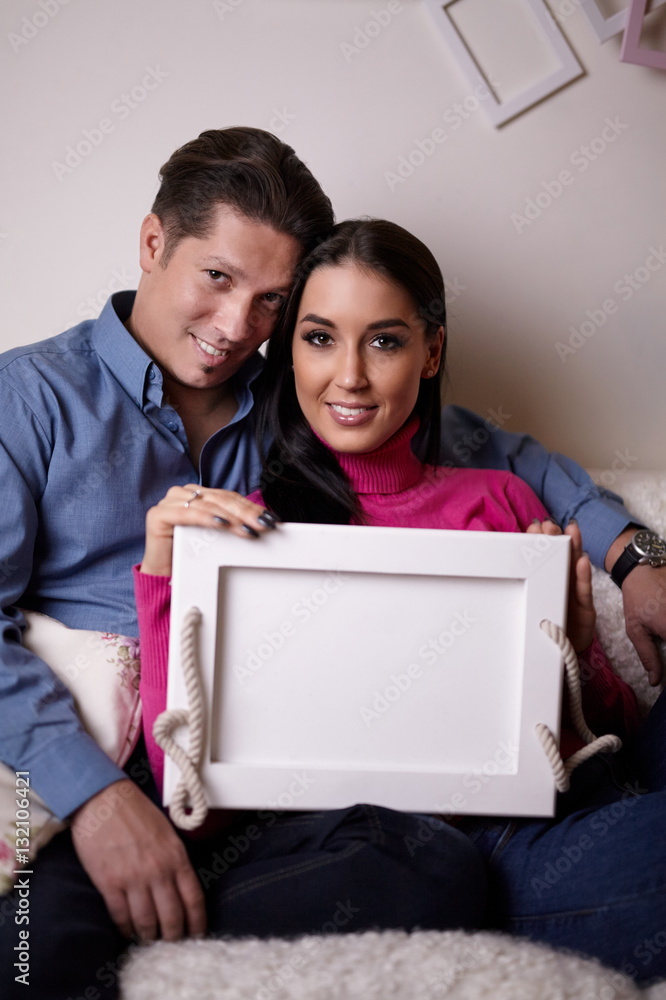 Lovely couple cuddling on sofa at home Lovely couple cuddling on sofa at home