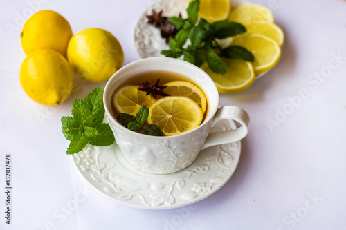 tea with lemon, honey, mint and spices on a white background