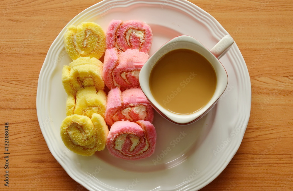 mini strawberry and vanilla jam roll with coffee on dish