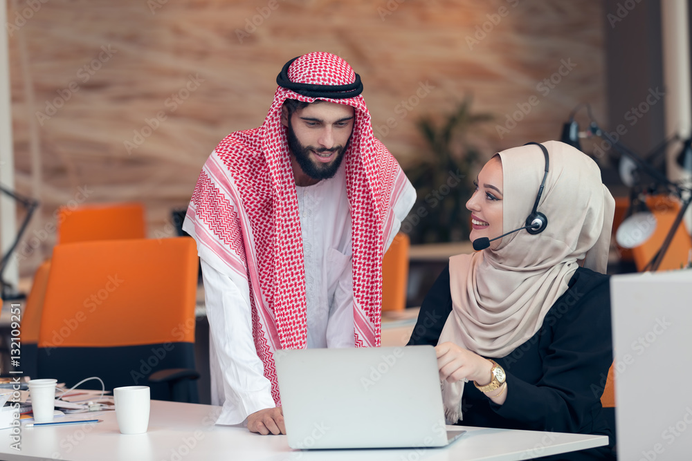 Arabic business couple working together on project at modern startup office Arabic business couple working together on project at modern startup office
