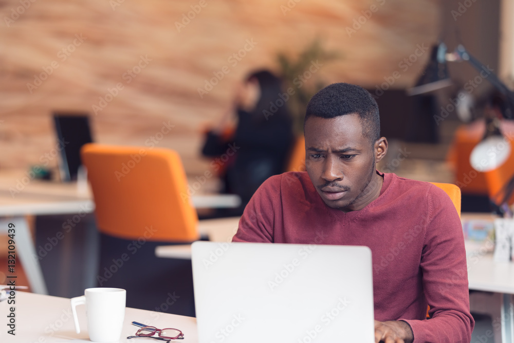 Young business man with a shocked expression working on a laptop Young business man with a shocked expression working on a laptop