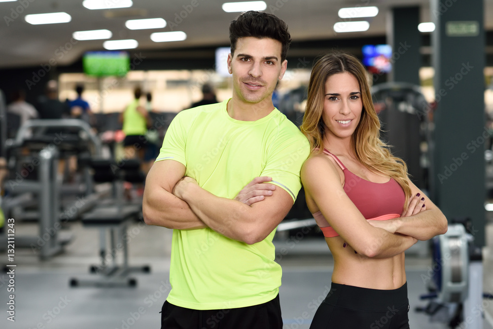 Man and woman personal trainers in the gym. Man and woman personal trainers in the gym.