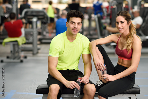 Man and woman drinking water after workout