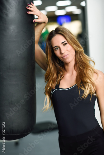 Female personal trainer with punching bag in a gym © javiindy