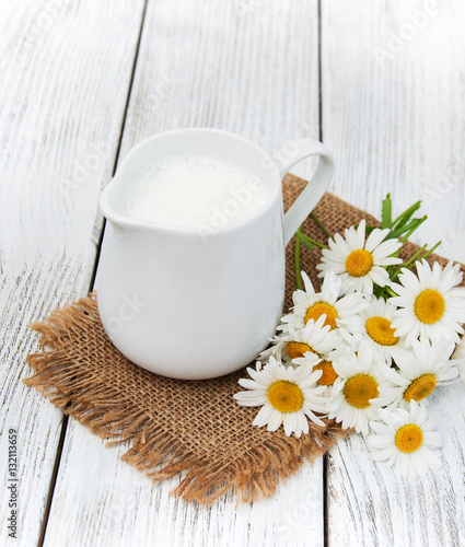 jug with milk  and chamomile flower