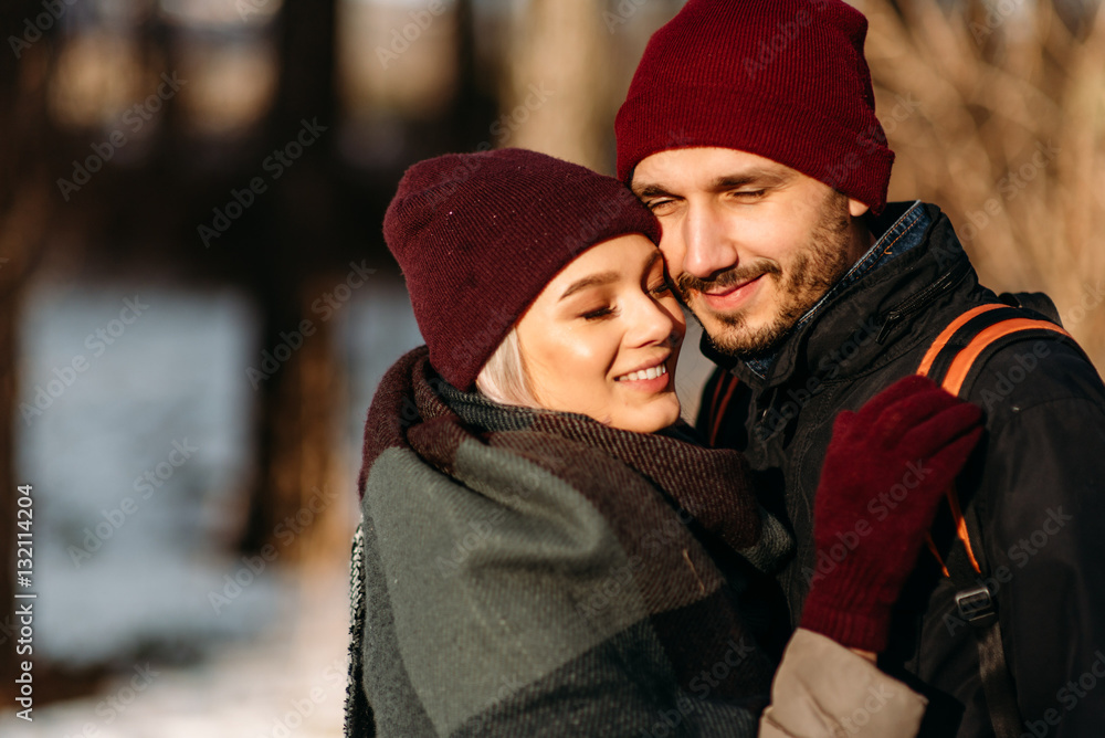 Young hipster couple hugging each other in winter park. Young hipster couple hugging each other in winter park.