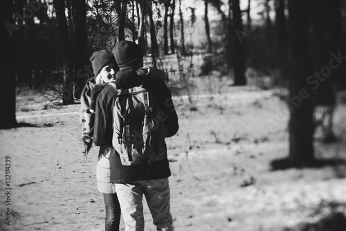 Young hipster couple hugging each other in winter park.