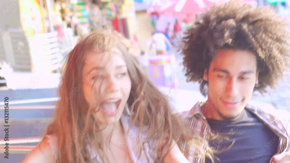 Young beautiful mixed race couple having fun in the amusement park Young beautiful mixed race couple having fun in the amusement park