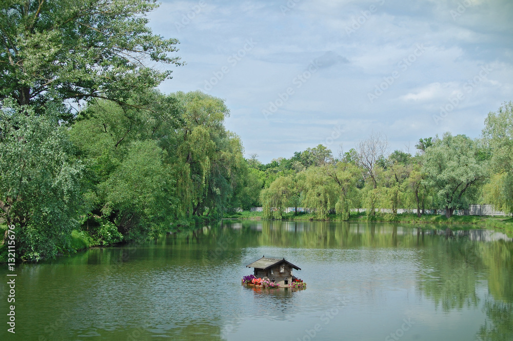 Floating duck house on water. Park with lake. Spring. Floating duck house on water. Park with lake. Spring.
