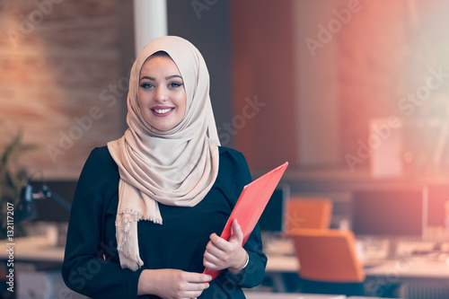 Arabian business woman holding a folder in modern startup office photo