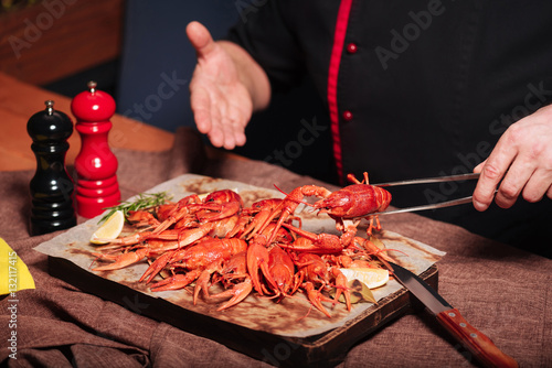 Close up of mans hands demonstrating crayfishes in restaurant