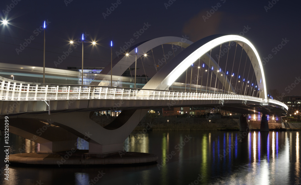Obraz premium Tram speeding over illuminated bridge Raymond Barre in Lyon at night.