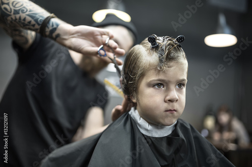 Haircut of small boy in barbershop