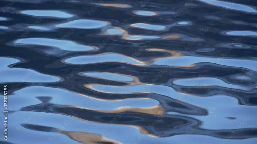 Ripples on the blue water with orange flares Ripples on the blue water with orange flares