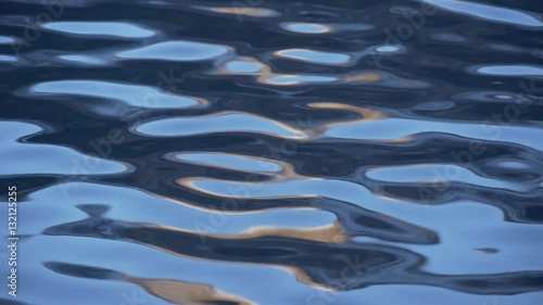 Ripples on the blue water with orange flares