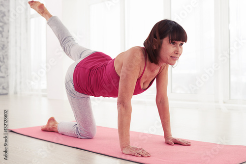 Close-up of concentrated woman doing pilates workout on a mat in