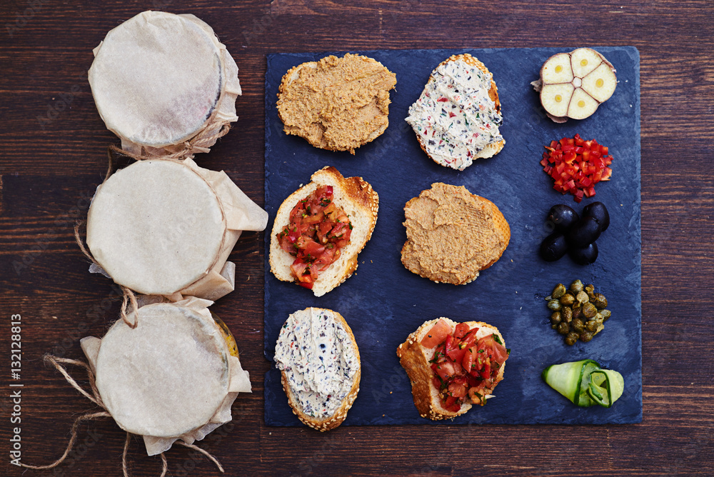 Collection of appetizers and salads in jars standing on a wooden Collection of appetizers and salads in jars standing on a wooden