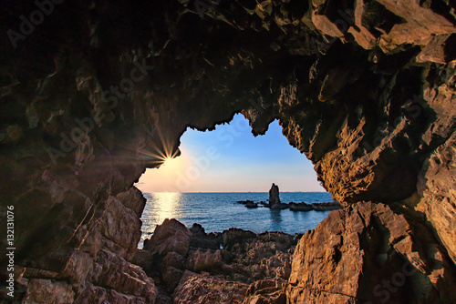 Rock standing alone, view from cave at sunset