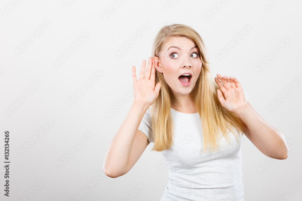 Woman putting hand ear to hear better Woman putting hand ear to hear better