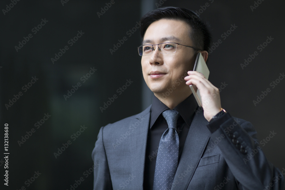 Mid adult businessman talking on cell phone Mid adult businessman talking on cell phone