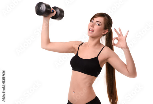 young smiling girl shows playful language and holds dumbbell, gesture okay hand on white background fitness