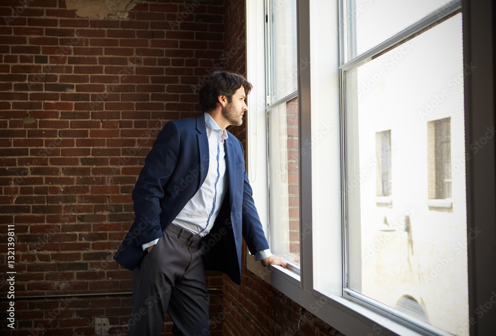 Businessman Standing By Office Window Businessman Standing By Office Window