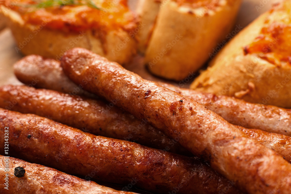 Appetizing grilled snack for beer background. Tasty golden bavarian sausages with toasts closeup, pub or restaurant menu backdrop. Junk food, german cuisine concept Appetizing grilled snack for beer background. Tasty golden bavarian sausages with toasts closeup, pub or restaurant menu backdrop. Junk food, german cuisine concept