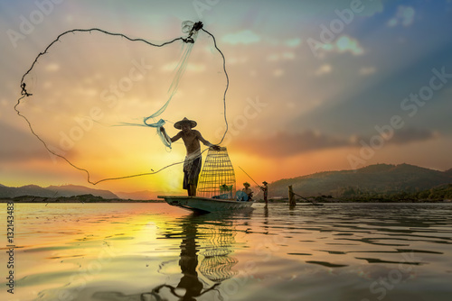 Asian Fishermen on boat fishing at lake photo