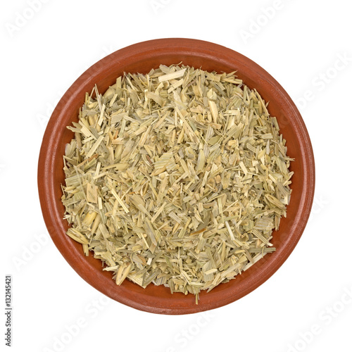 Bowl of oatstraw herb on a white background top view.