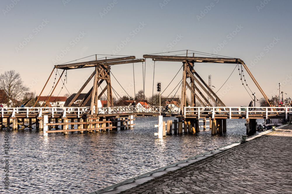 Fototapeta premium Germany, Greifswald, Wieck: Old wooden draw bridge, river Ryck and houses in the background. The bridge has been build in 1887.