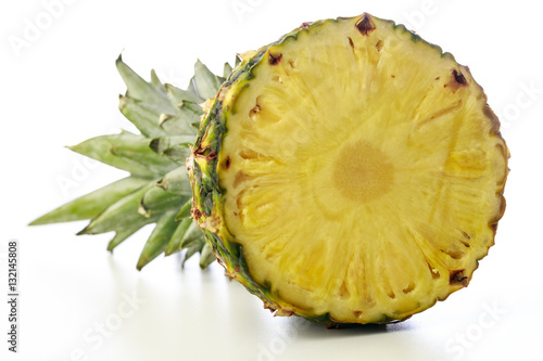 Head of a pineapple with leaf against a white background front view