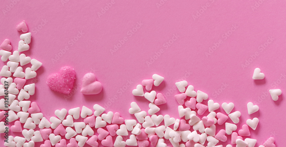 Obraz premium Zuckerherzen auf rosa Untergrund
