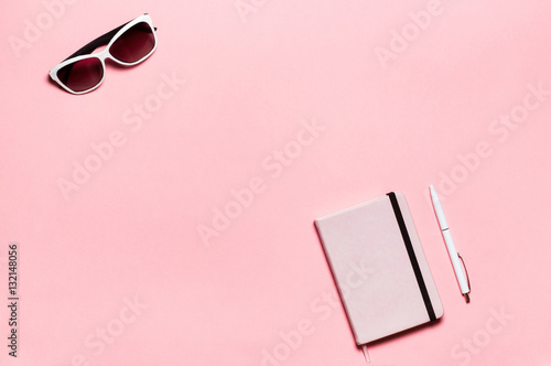 Pink diary, white pen, glasses on  textplace background. flat lay, top view. Feminine workspace photo