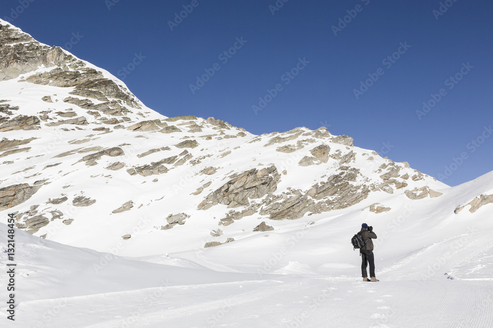 Man photographing snowy landscape of Italian alps