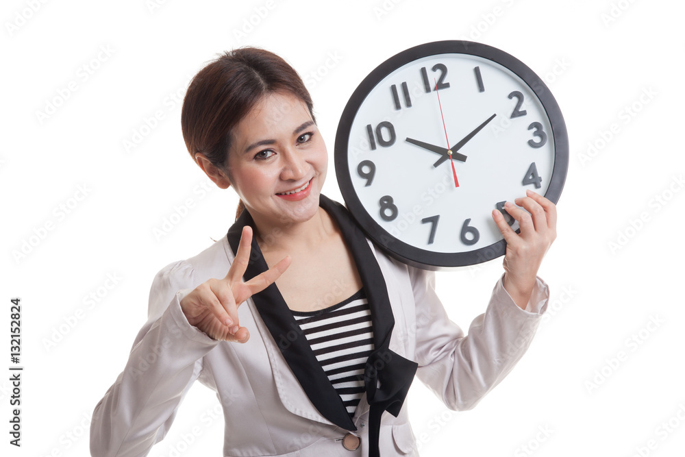 Young Asian business woman show victory sign with a clock. Young Asian business woman show victory sign with a clock.