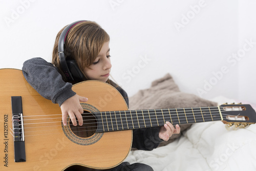 Little girl learning to play classical guitar
