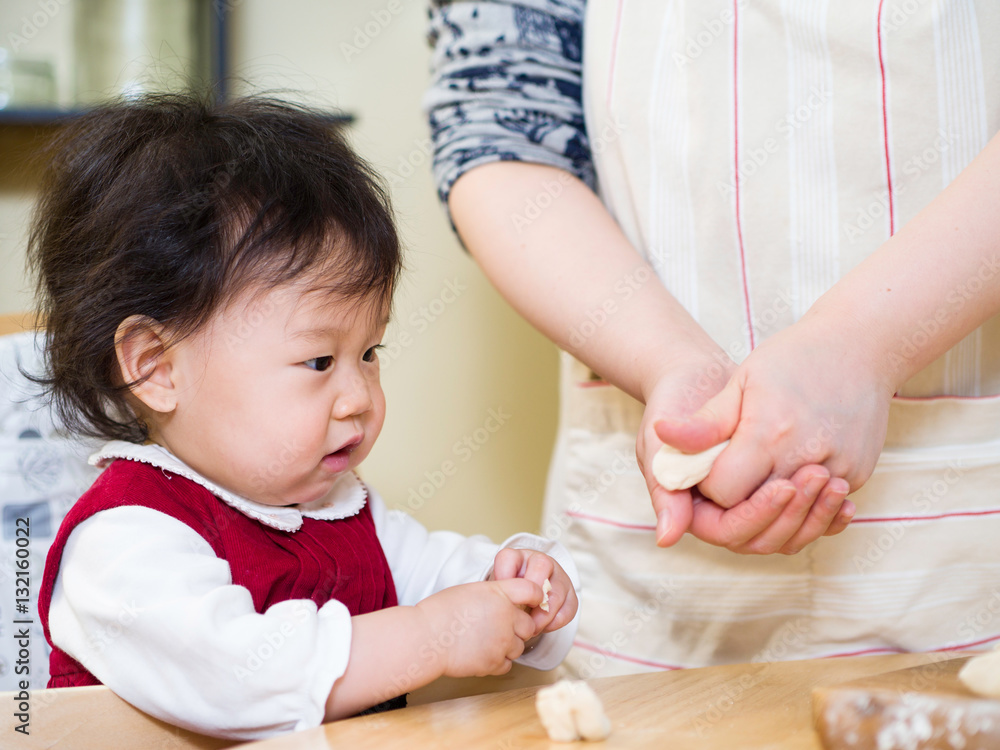 Adorable baby girl making gyoza with mom Adorable baby girl making gyoza with mom