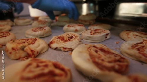 Bakery worker arranging pastries before baking photo