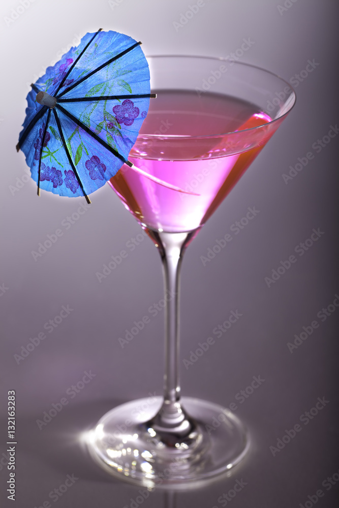 Party girl. Pink party cocktail with blue umbrella Party girl. Pink party cocktail with blue umbrella