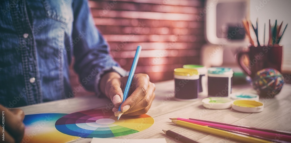 Graphic designer drawing on colour chart Graphic designer drawing on colour chart