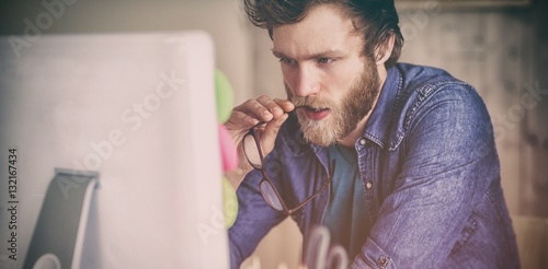 Focused hipster working at his desk photo