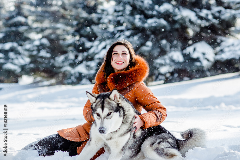 Fototapeta premium Girl playing with a dog in the park in winter.