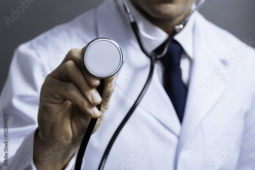 Close up of doctors hands holding stethoscope