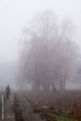 samotny mężczyzna spacerujący w gęstej mgle