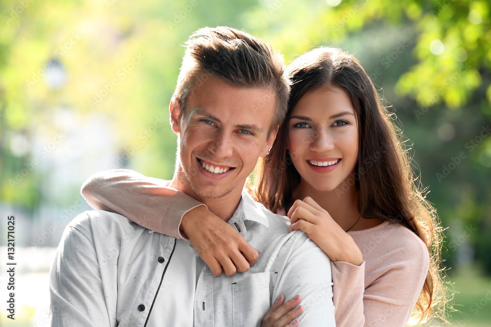 Fototapeta premium Portrait of beautiful young couple outdoors on blurred background