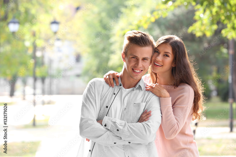Fototapeta premium Beautiful young couple outdoors on blurred background
