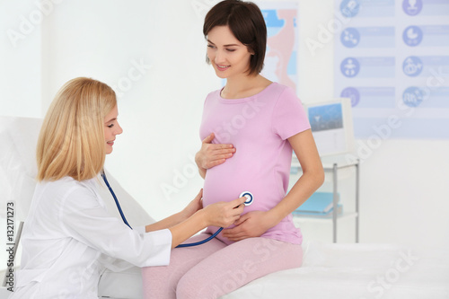 Doctor examining young preg...